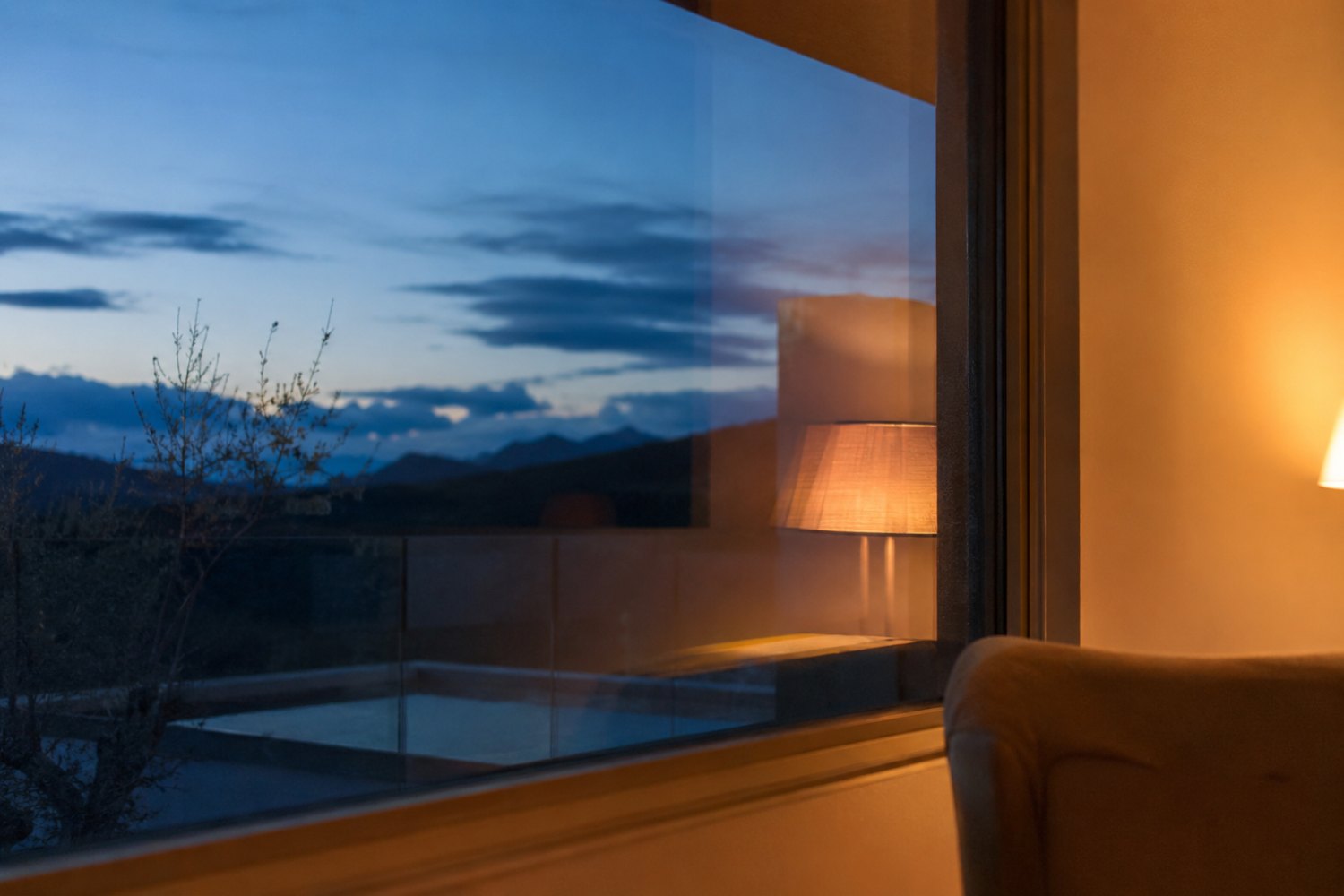 La métacognition : une baie vitrée au crépuscule, lampe chaude reflétée - la position d'observateur intérieur